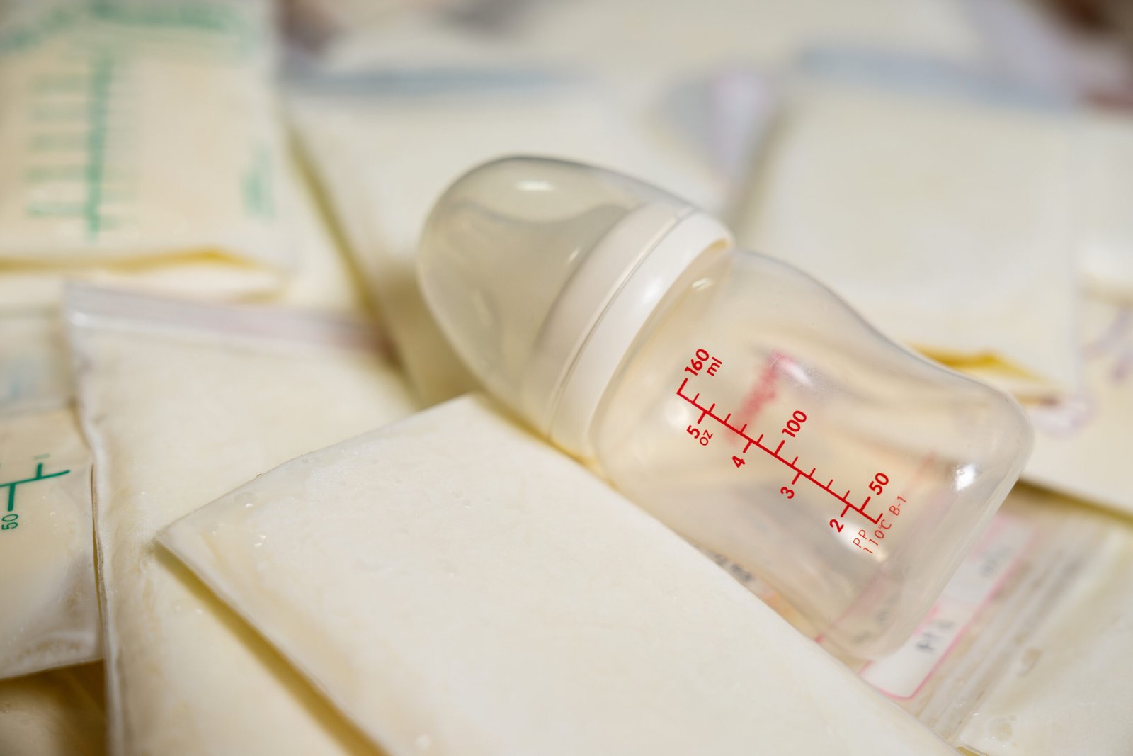 breast milk storage bags, bottles and frozen breast milk for new baby, breast pumping milk concept. selective focus.
