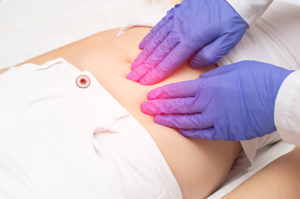 About a gynecologist doctor probes the lower abdomen of a girl who has pain and inflammation of the reproductive system. ovarian cyst, endometriosis, pregnancy pathology